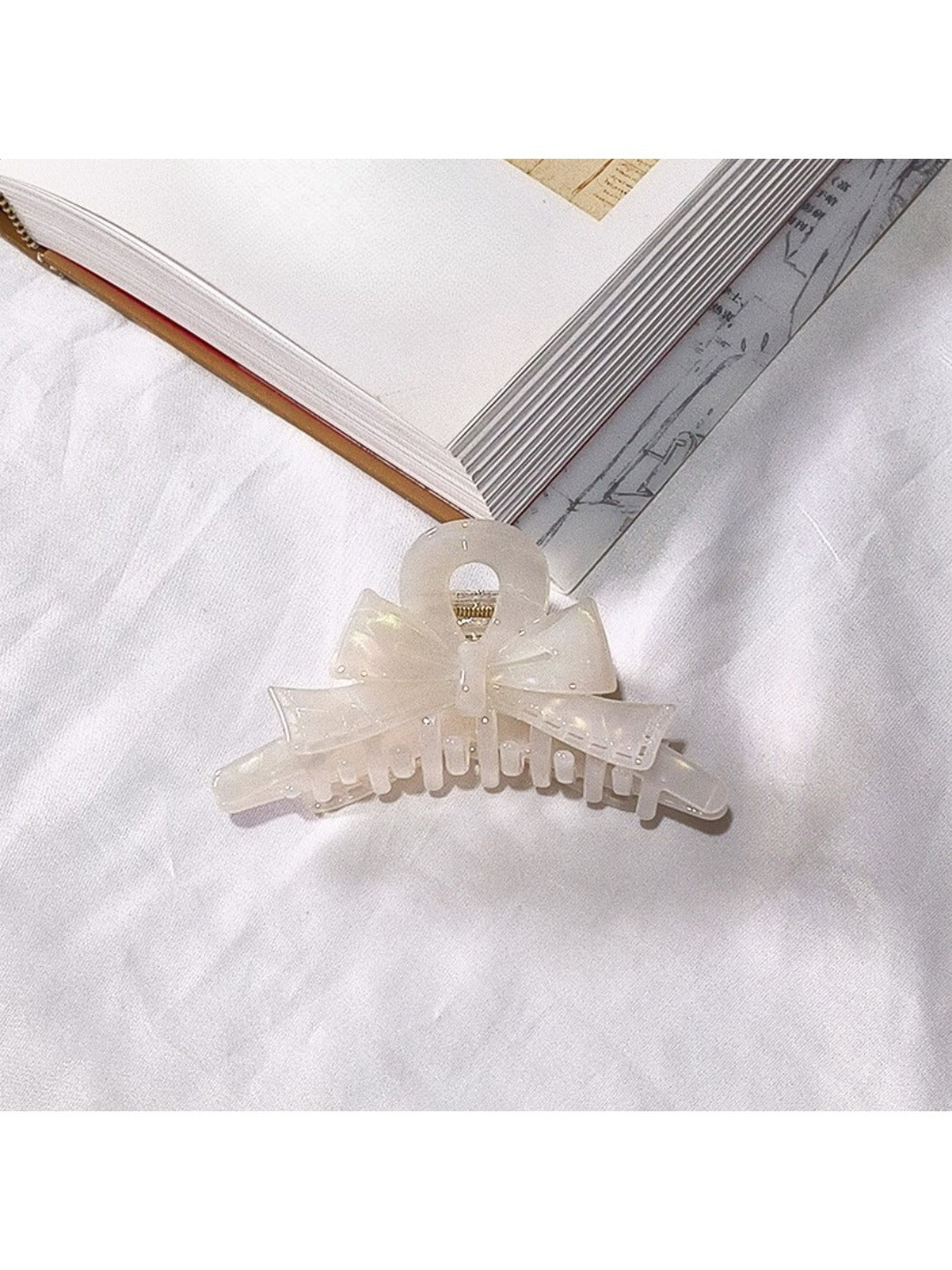 Beau acetate bow shaped claw clip with light reflection on glossy surface