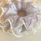 Side view of the purple ruched scrunchie highlighting gathered fabric design