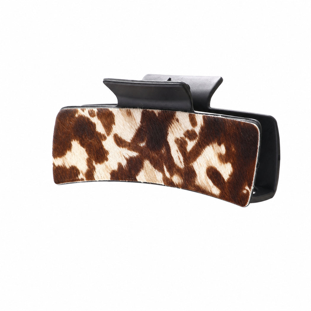 Brown and cream cow-print curved hair claw, side view