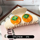 Yellow fruit shaped claw clip securing hair in a bun