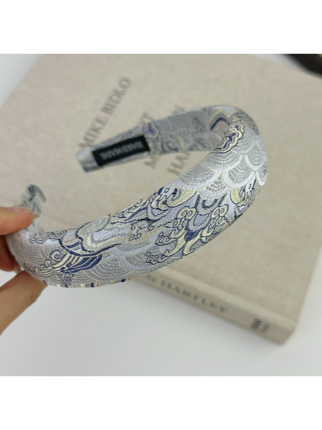 Gifty fabric headband with embroidered flowers displayed on mannequin