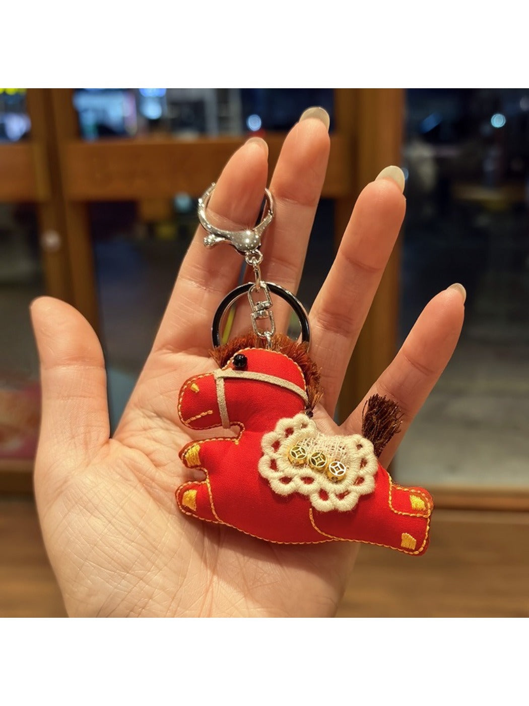 Keypus pony charm keychain next to a notebook and pen on a desk