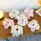 Close-up of Gifty minimalist colorful ruffled scrunchie in pastel pink fabric