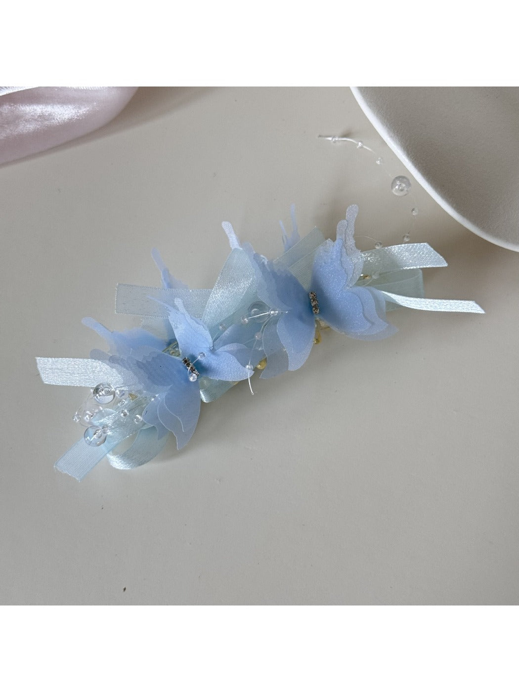 Top view of the banana clip showing symmetrical butterfly decorations along the clip