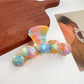 Beau hair claw clip in glossy finish resting on a marble countertop