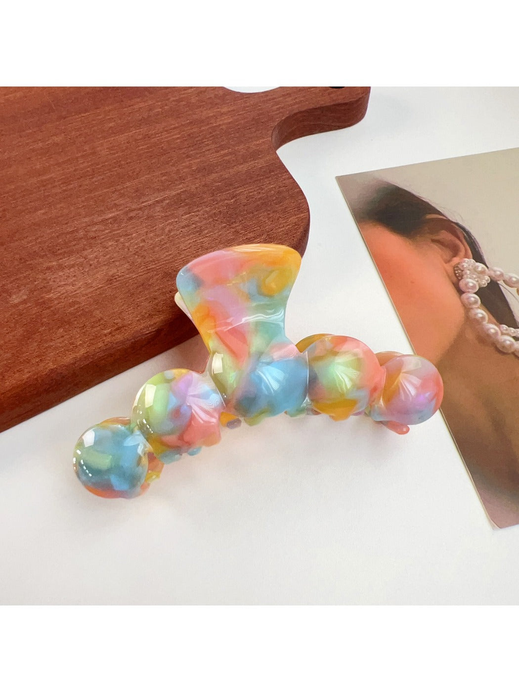 Beau hair claw clip in glossy finish resting on a marble countertop