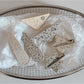 Beau printed triangle star hair clip with black and white star pattern on a beige background