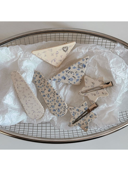 Beau printed triangle star hair clip with black and white star pattern on a beige background