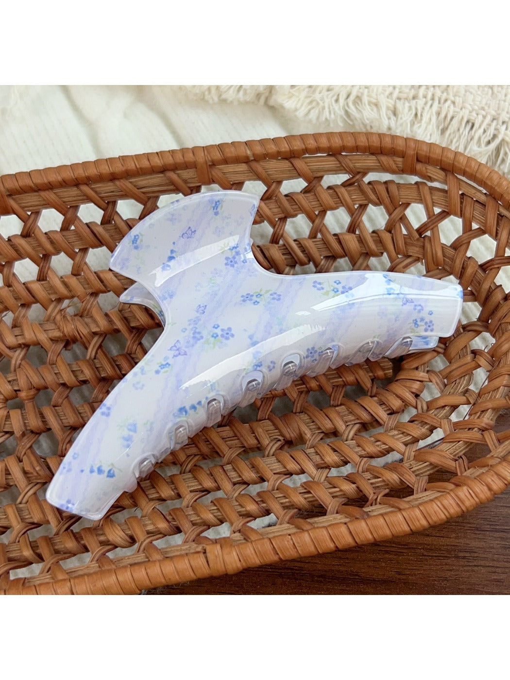 Beau blue floral print hair claw clip held in hand showing size