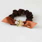 Gifty hair tie shown in packaging with branding and floral embellishments visible