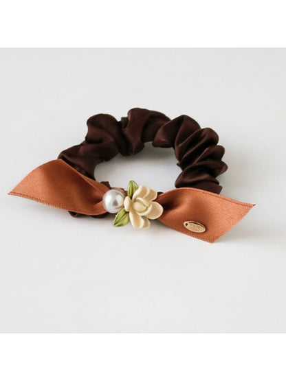 Gifty hair tie shown in packaging with branding and floral embellishments visible