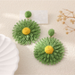 Colorful floral raffia earrings displayed with matching accessories