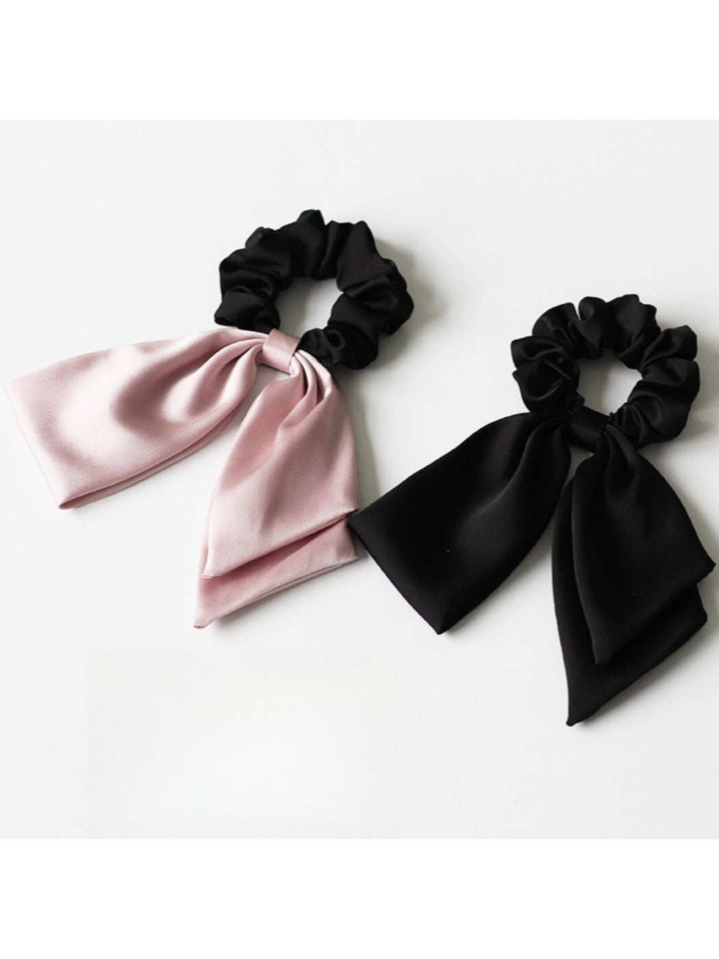 Satin bow hair tie styled on a model's blonde hair in a ponytail