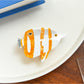 Beau tropical fish hair clip resting on wooden surface highlighting color contrast
