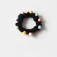 Assorted pastel beaded hair ties arranged in a fan shape on a flat surface