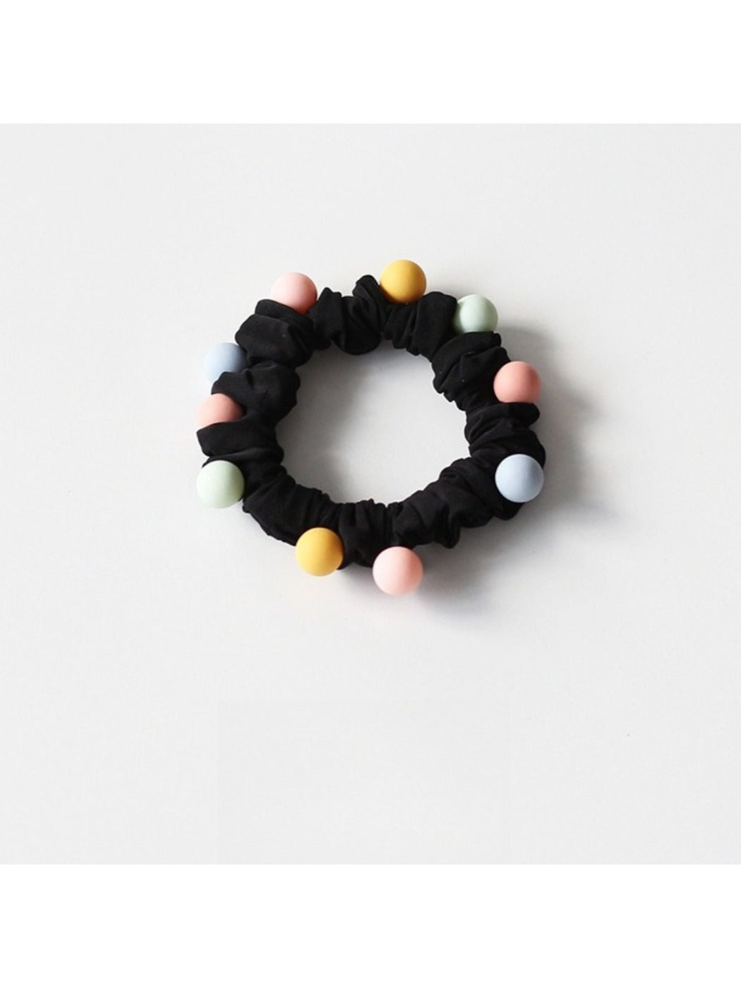 Assorted pastel beaded hair ties arranged in a fan shape on a flat surface