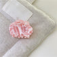Beau dreamy cloud hair claw clip on a textured fabric background
