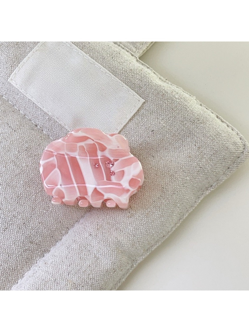 Beau dreamy cloud hair claw clip on a textured fabric background