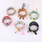 Close-up of Lovra trendy stackable beaded bracelets in various colors on a white background