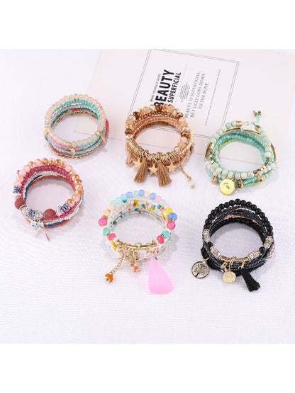 Close-up of Lovra trendy stackable beaded bracelets in various colors on a white background