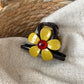 Beau flower-shaped claw clip displayed on a wooden surface