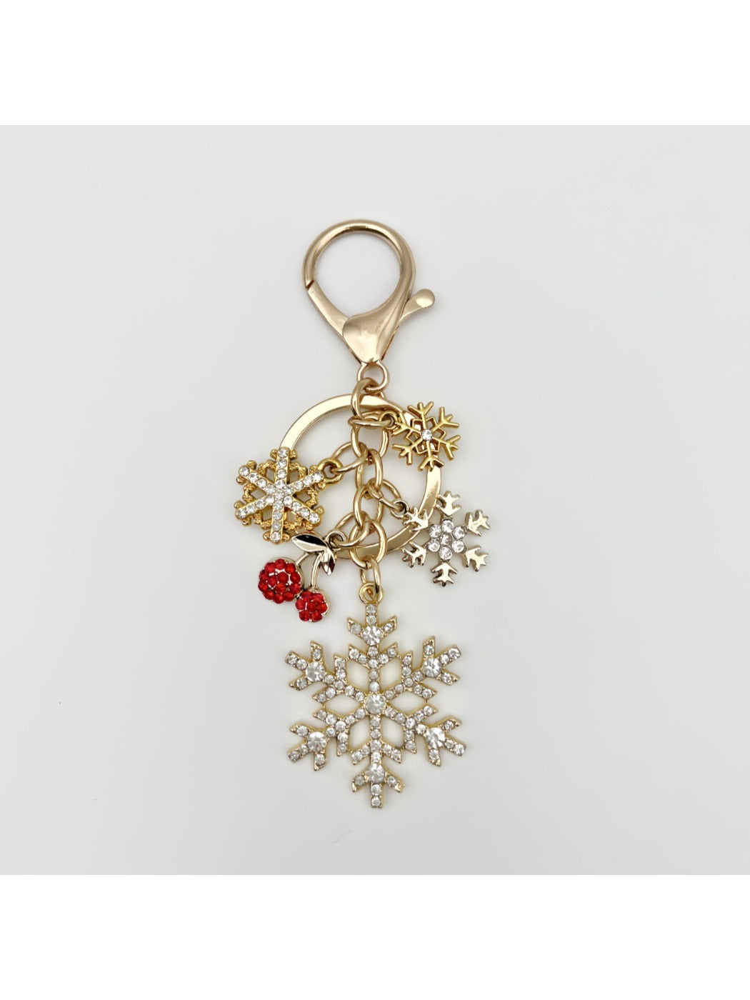 Hand holding delicate snowflake pendant keychain with silver keyring