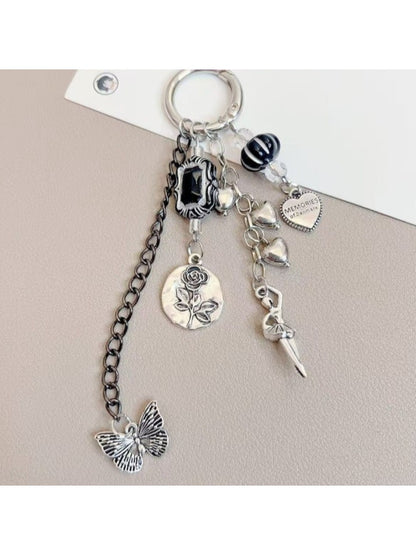 Silver dancing girl charm keychain displayed on a wooden surface