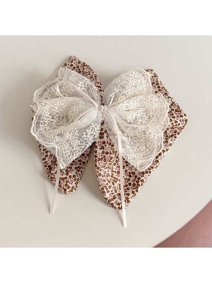 Beau tiny floral lace bow claw clip displayed on a model's hair