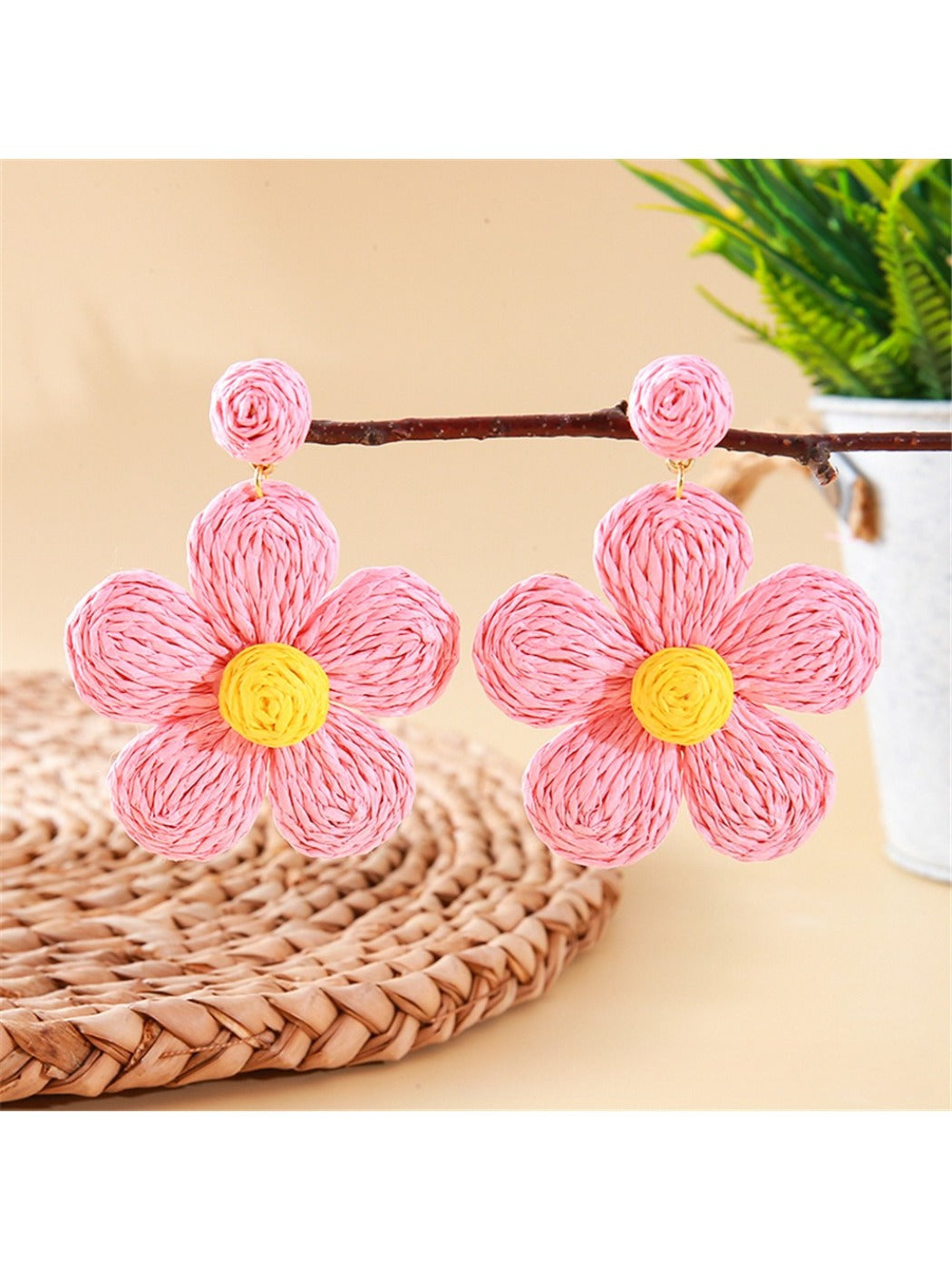 Model holding earedge knitted flower earrings near her ear