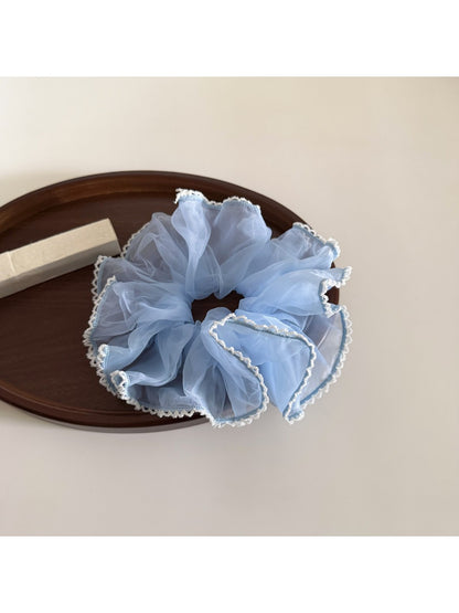 Multiple Gifty ruffled scrunchies in different solid colors displayed together