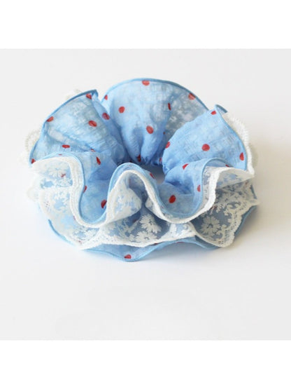 Gifty scrunchie styled on a wrist with vintage polka dot pattern