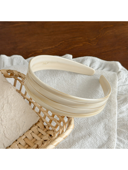 Gifty wide geometric headband next to matching accessories on white background