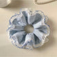 Navy blue scrunchie with retro white and light blue stripes on a white background