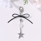 Keypus keychain with bow, star, and heart charms on a white background