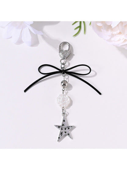 Keypus keychain with bow, star, and heart charms on a white background