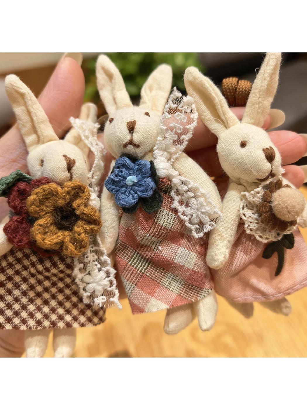 Rabbit charm keychain hanging from a set of keys on a wooden surface