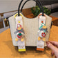 Keypus duck charm keychain hanging from a set of keys on a wooden surface