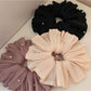 Large satin scrunchie styled on a wrist as a fashion accessory