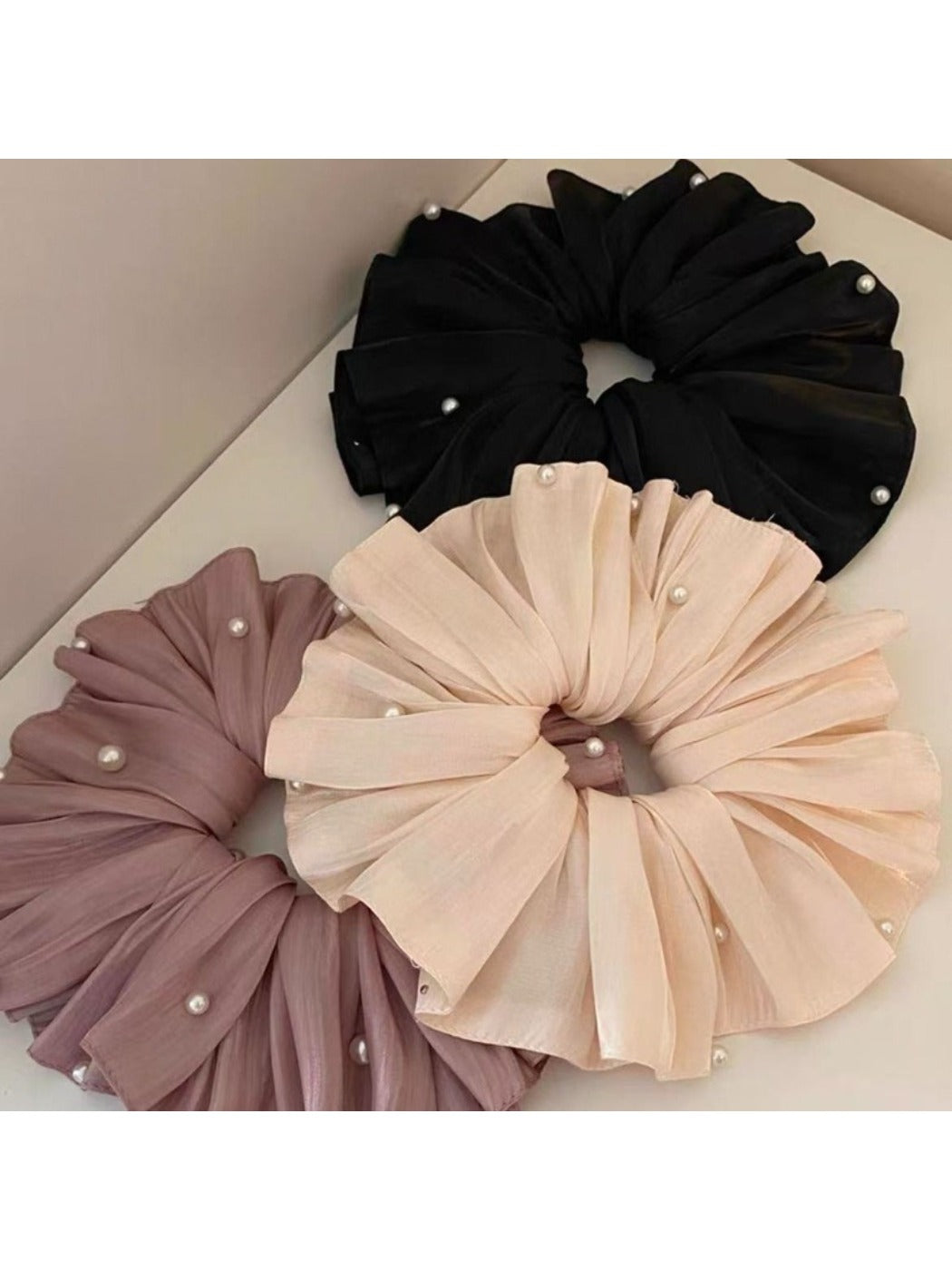 Large satin scrunchie styled on a wrist as a fashion accessory