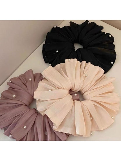 Large satin scrunchie styled on a wrist as a fashion accessory