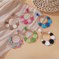 Close-up of Sweet Raffia Circle Stud Earrings with woven raffia texture