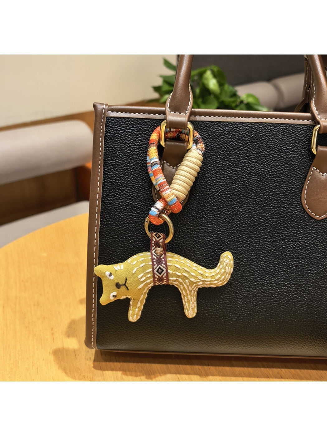 Person holding the fox charm keychain between fingers