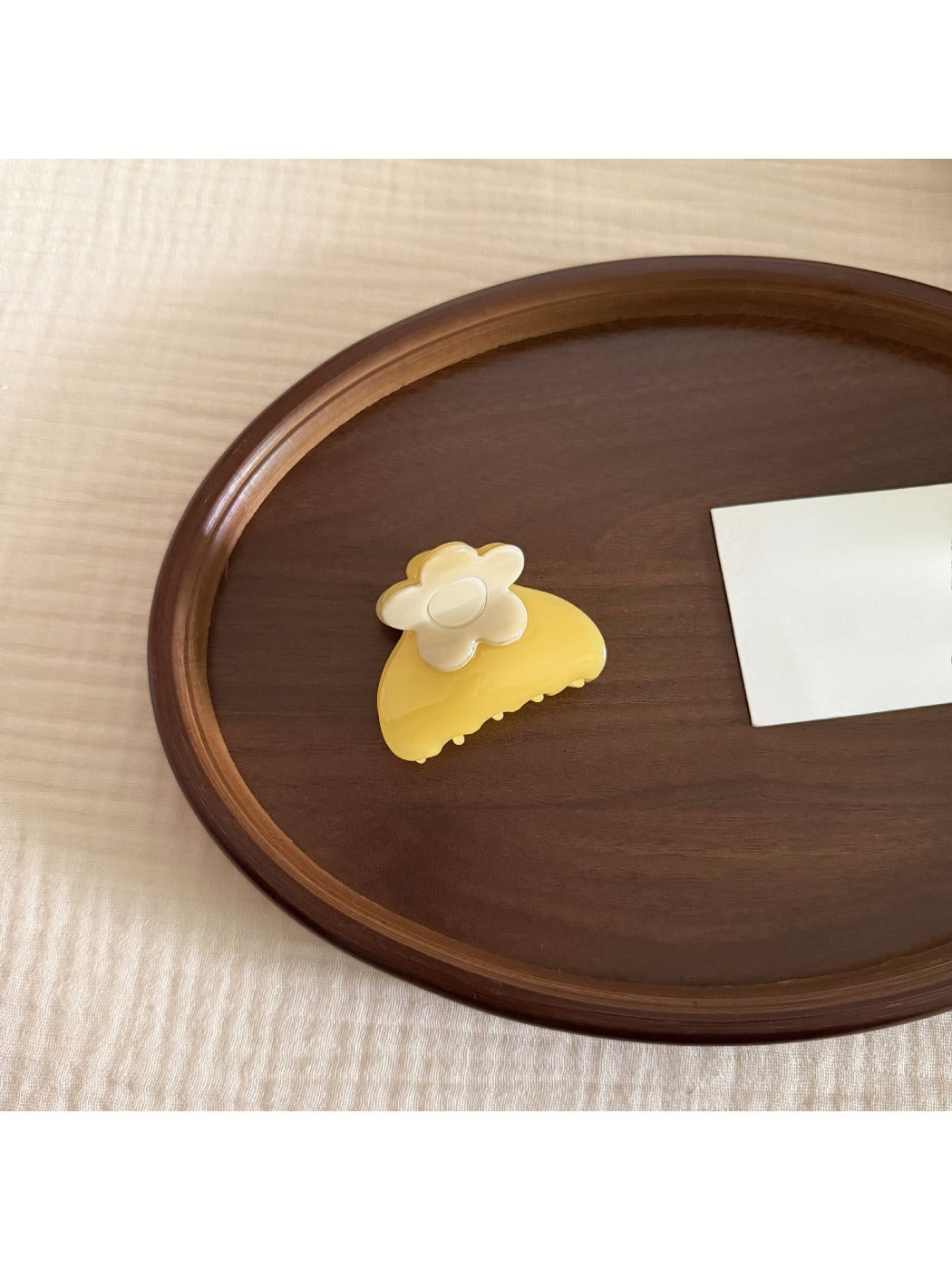 Beau hair clip held in hand displaying size and floral acetate material