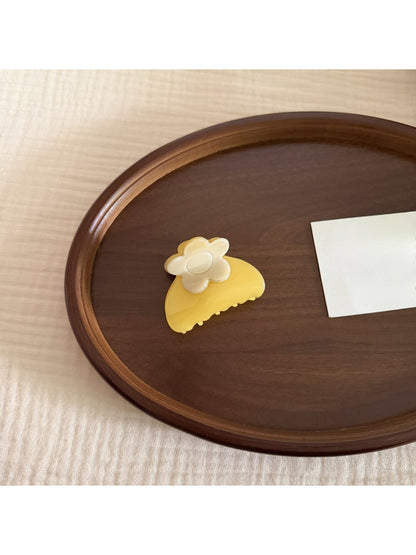 Beau hair clip held in hand displaying size and floral acetate material