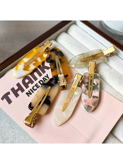 Side view of Beau acetate invisible hair clip displaying metal spring mechanism