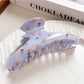 Beau shark claw clip placed on wooden surface highlighting design