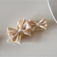 Beau satin bow banana clip held in hand showing size and shape