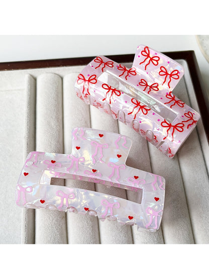 Close-up of black bow print on clear acetate claw clip
