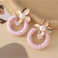 Earedge round floral pendant earrings shown with matching necklace on display