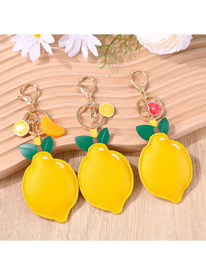 Yellow lemon-shaped keychain with green leaf detail on a silver keyring